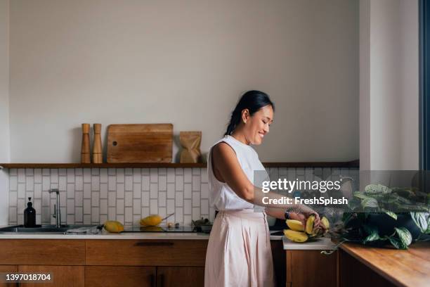 asian woman taking a banana - banana phone stock pictures, royalty-free photos & images