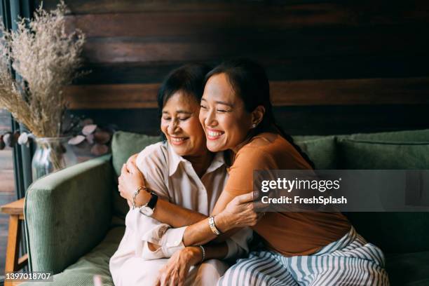mother and daughter hugging each other - seniors embracing stock pictures, royalty-free photos & images