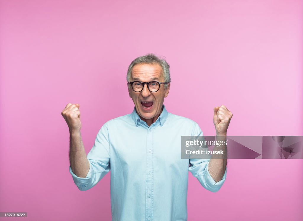 Excited man shouting while gesturing with fists