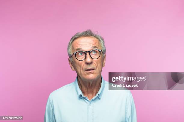 schockierter älterer mann im ruhestand, der aufblickt - portrait of business man looking surprised stock-fotos und bilder