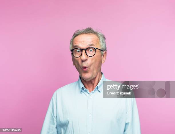 schockierter älterer mann im ruhestand, der sein gesicht macht - überraschung stock-fotos und bilder