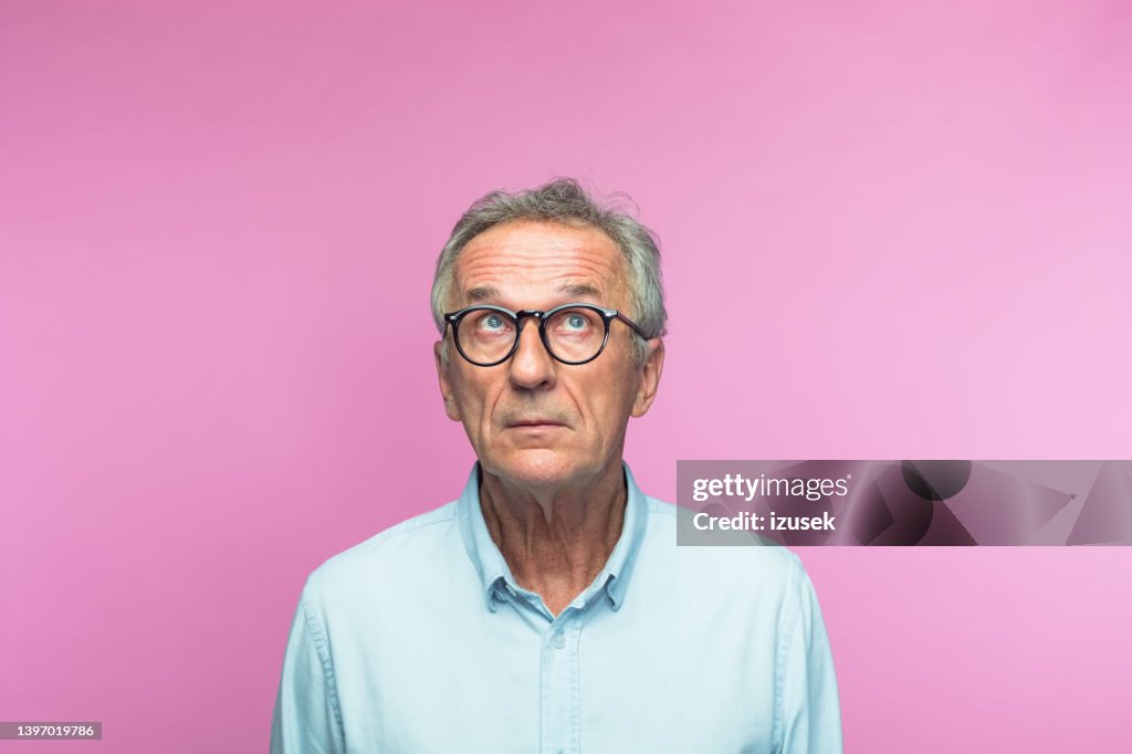 Nachdenklicher älterer Mann im Ruhestand, der nach oben schaut