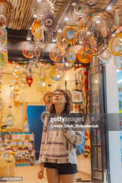 femme choisissant des moulinets suspendus dans une boutique de souvenirs à playa del carmen, mexique - playa del carmen photos et images de collection