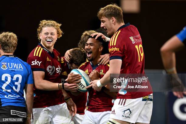 Folau Fakatava of the Highlanders celebrates a try with Scott Gregory of the Highlanders and Fabian Holland of the Highlanders during the round 13...