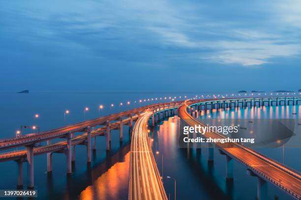 cross-sea bridge at dusk. - route perspective photos et images de collection
