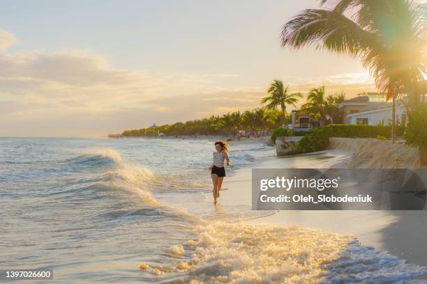 woman running on the beach at sunset - mayan riviera stock pictures, royalty-free photos & images