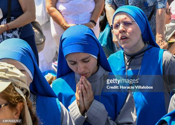 Young nuns pray while kneeling at the end of the farewell procession during the last day ceremonies of the two-day international pilgrimage in...
