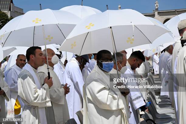 Priests protect themselves against the strong sun with white umbrellas at the end of the farewell procession during the last day ceremonies of the...