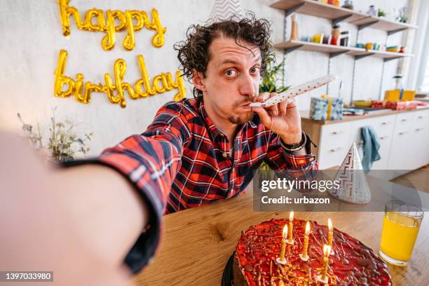 junger mann, der ein selfie macht, während er seinen geburtstag feiert - blowing out candles pov stock-fotos und bilder