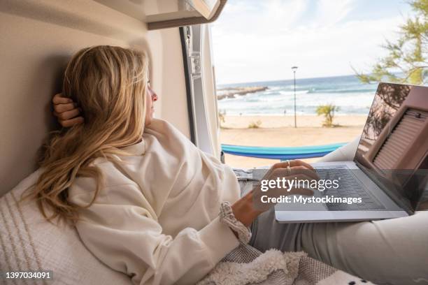 mujer trabajando en línea desde su autocaravana - labor camp fotografías e imágenes de stock