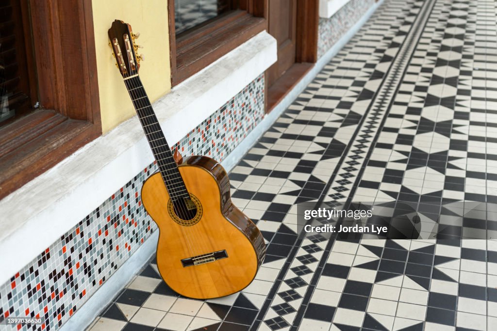 Spanish guitar resting on a wall with vintage tiles