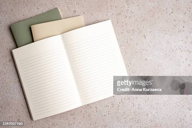 three note pads stacked - two closed and one with blank lined paper open, top view. with copy space. - ドリル ストックフォトと画像