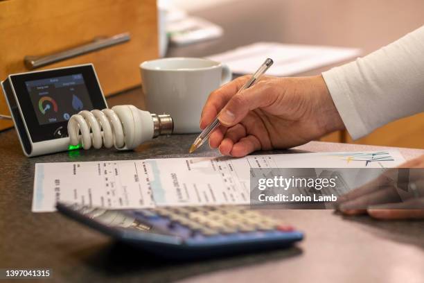 close-up of energy bills and smart meter on a kitchen worktop. - luce elettrica foto e immagini stock