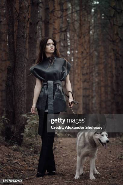 female portrait of woman outdoors in the forest with wild dog together. fairy tale atmosphere in dark. fashion people. woodland dweller in the nature. friendship of human and animal like a wolf - paganismo imagens e fotografias de stock