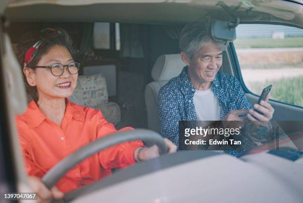 road trip asiatique chinois senior couple voyageant avec camping-car dans une zone rurale avec application mobile guide de direction de carte - older couple travelling photos et images de collection