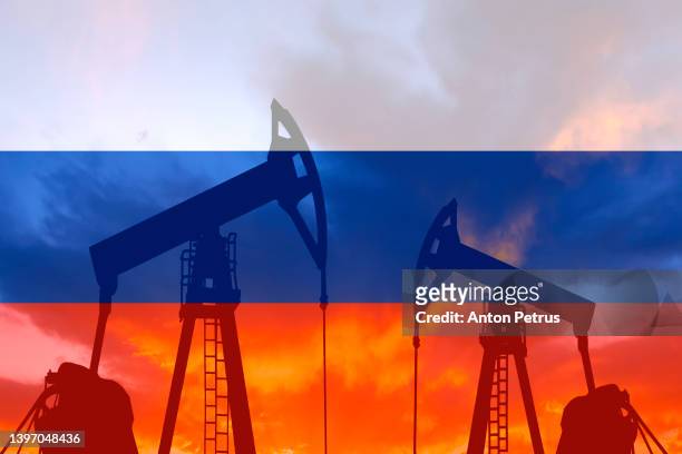 oil pump on the background of of the russian flag - oil gas stock-fotos und bilder