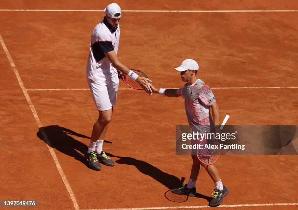 John Isner of the United States shakes hand with Diego Schwartzman of Argentina during the Men's Doubles Round 4 match between Harri Heliovaara of...