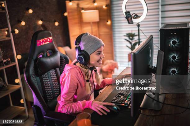 girl plays video game online and streaming   at home - game one stockfoto's en -beelden