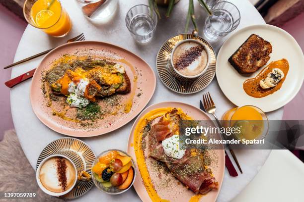 weekend brunch with toasts, fresh fruits, banana bread, orange juice and coffee served in a restaurant, overhead view - boniato fotografías e imágenes de stock