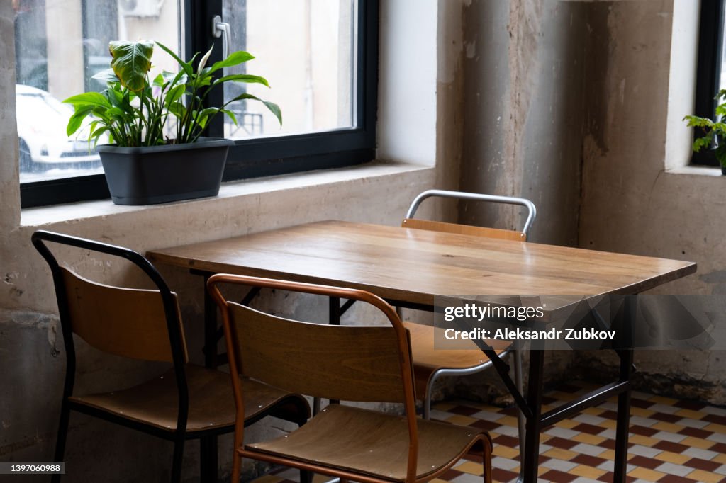 Tables and chairs in an empty cafe, office, coworking or room. Stylish design, vintage style. Closed restaurant, isolation due to covid and coronavirus. A place for breakfast and meetings, a kitchen. There are no visitors due to the global crisis.