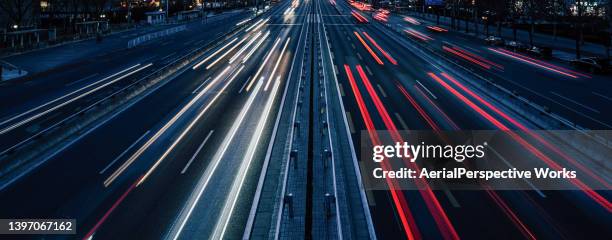 tráfico ocupado, tráfico que se mueve en ambas direcciones al anochecer - vehicle light fotografías e imágenes de stock