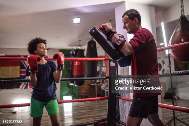 male boxing coach preparing black teen girl for boxing match - girl punch stock pictures, royalty-free photos & images