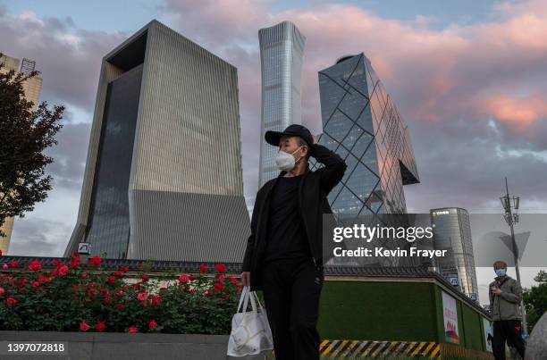 Man wears a protective mask as he walks by the skyline of the Central Business District on a quiet evening days after the local government issued a...