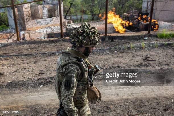 Ukrainian Army soldier walks past a burning natural gas terminal on May 13, 2022 on the northern outskirts of Kharkiv, Ukraine. Ukrainian and Western...