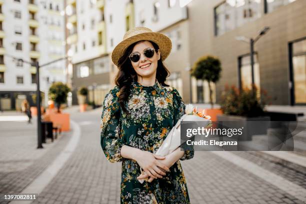 portrait of young woman holding bouquet of tulips - floral dress stock pictures, royalty-free photos & images