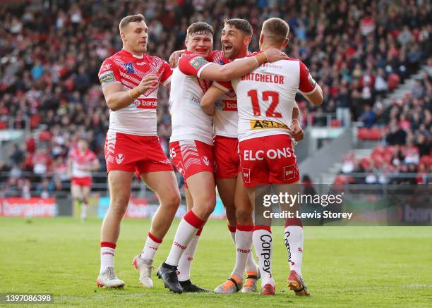 Tommy Makinson of St Helens celebrates after scoring their side's first try with Matty Lees, Ben Davies and Joe Batchelor and team mates during the...