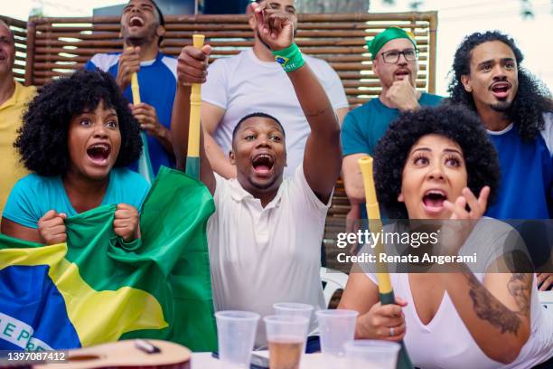 amigos brasileños viendo partidos de fútbol y animando juntos - banderas latinoamerica fotografías e imágenes de stock