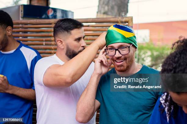gay couple putting brazil bandana on forehead - fan scarf bildbanksfoton och bilder