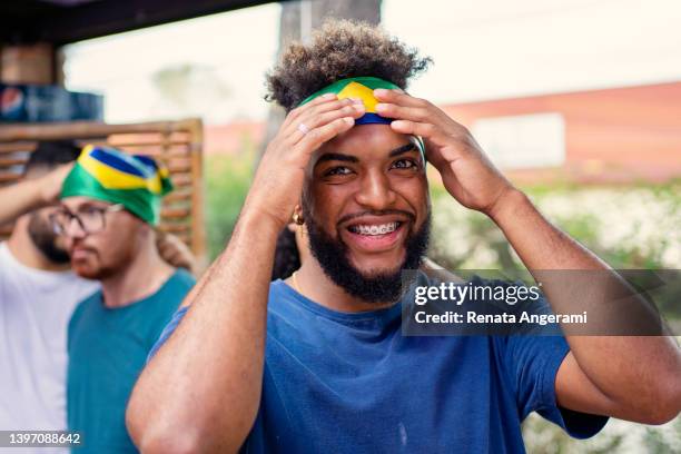 black man putting brazil bandana on forehead - black bandana stock pictures, royalty-free photos & images