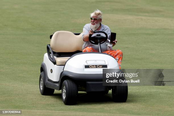 John Daly drives a golf cart across the 11th hole during the second round of the Regions Tradition at Greystone Golf and Country Club on May 13, 2022...