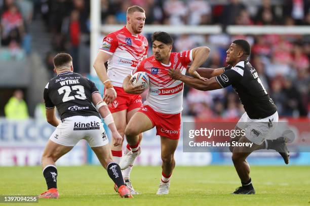 James Bell of St Helens is tackled by Joe Lovodua of Hull FC during the Betfred Super League Round 12 match between St Helens and Hull FC at Totally...
