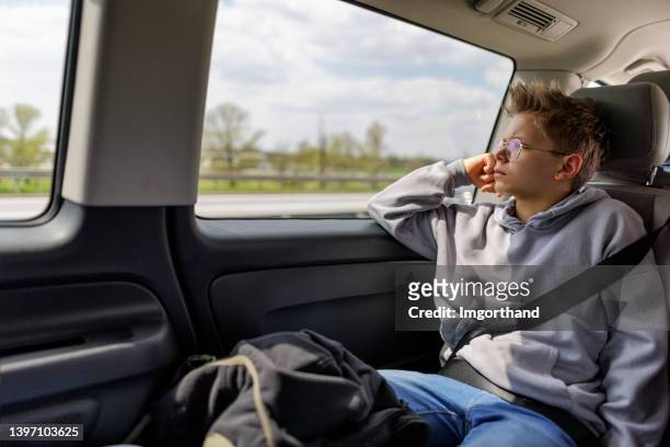 teenage boy travelling by car - teenage boy looking out window stock pictures, royalty-free photos & images
