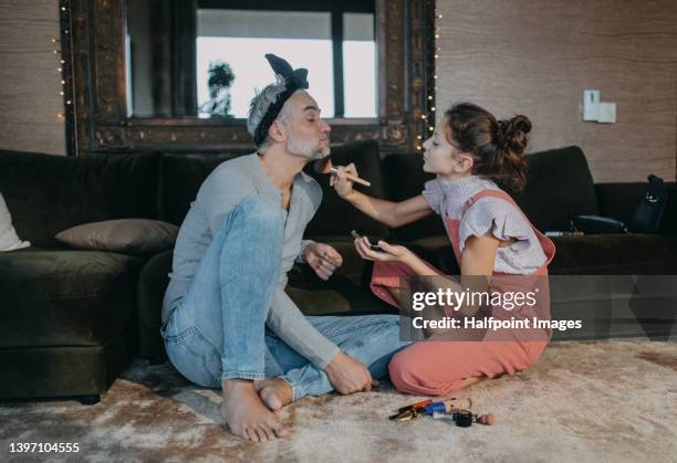 father and teen daughter applying make up together at home. - kids makeup face stock pictures, royalty-free photos & images