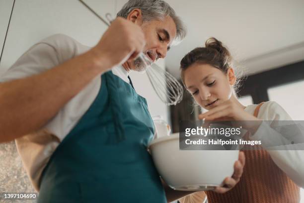 teenage girl with her father cooking in kitchen together. - family teenager home life bildbanksfoton och bilder