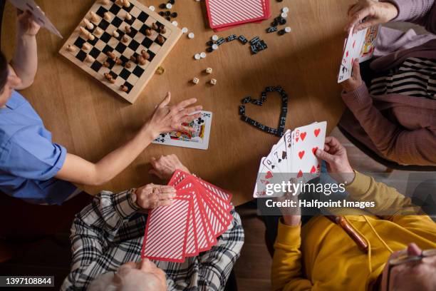 seniors playing cards in their retirement home - game night foto e immagini stock