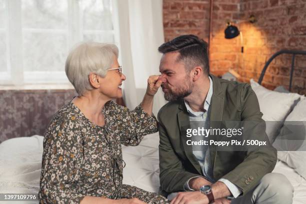 delighted caucasian female pensioner fooling around and grabbing her - mother congratulating stock pictures, royalty-free photos & images