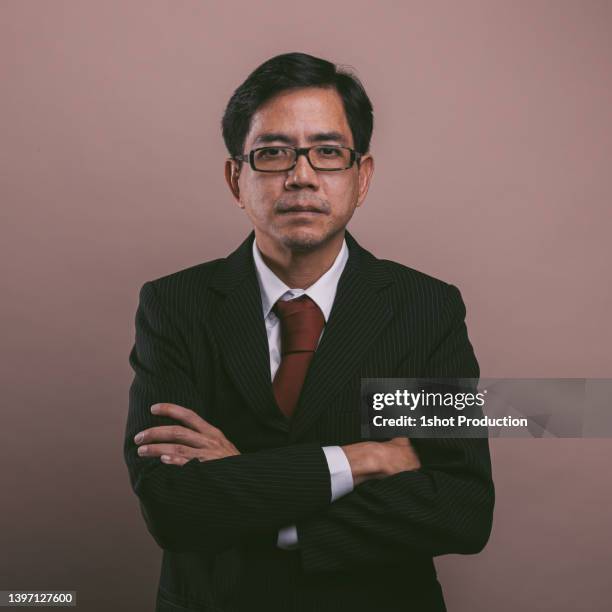 asian businessman portrait, looking at camera. confidence. - bruin pak stockfoto's en -beelden