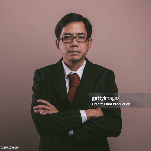 asian businessman portrait, looking at camera. confidence. - brown suit stock pictures, royalty-free photos & images