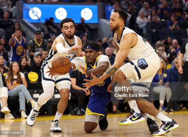 Kevon Looney of the Golden State Warriors reaches for the ball against Tyus Jones and Kyle Anderson of the Memphis Grizzlies during the first quarter...