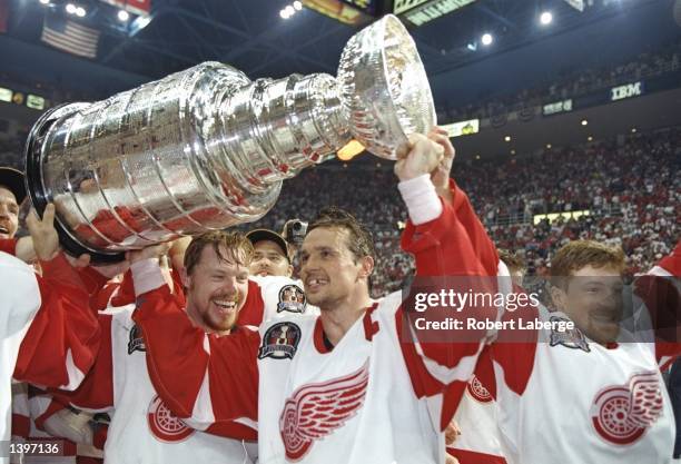 Centers Steve Yzerman and Kris Draper of the Detroit Red Wings celebrate with the Stanley Cup after a playoff game against the Philadelphia Flyers at...