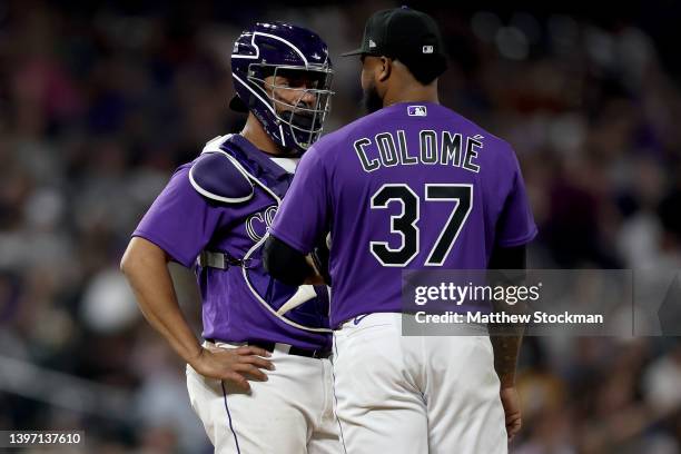 Pitcher Alex Colome of the Colorado Rockies confers with catcher Elias Diaz while throwing against the Kansas City Royals in the seventh inning at...