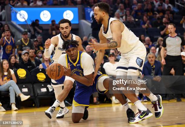 Kevon Looney of the Golden State Warriors reaches for the ball against Tyus Jones and Kyle Anderson of the Memphis Grizzlies during the first quarter...