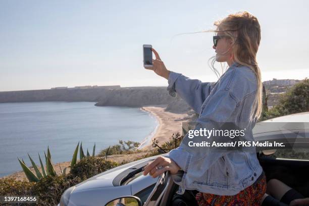 young woman relaxes outside car, by coastline - sagres imagens e fotografias de stock