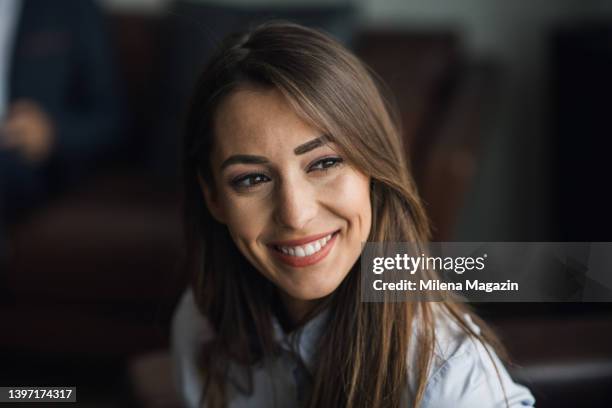 close-up of a beautiful young businesswoman smiling - small office stock pictures, royalty-free photos & images