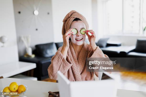 portrait of young woman applying face mask at home. natural skin care routine for glowing skin. woman at home having skin care routine. concept of natural cosmetics skin care - homemade mask stock pictures, royalty-free photos & images