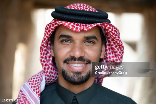 headshot of confident young saudi man in traditional attire - ksa people stock pictures, royalty-free photos & images